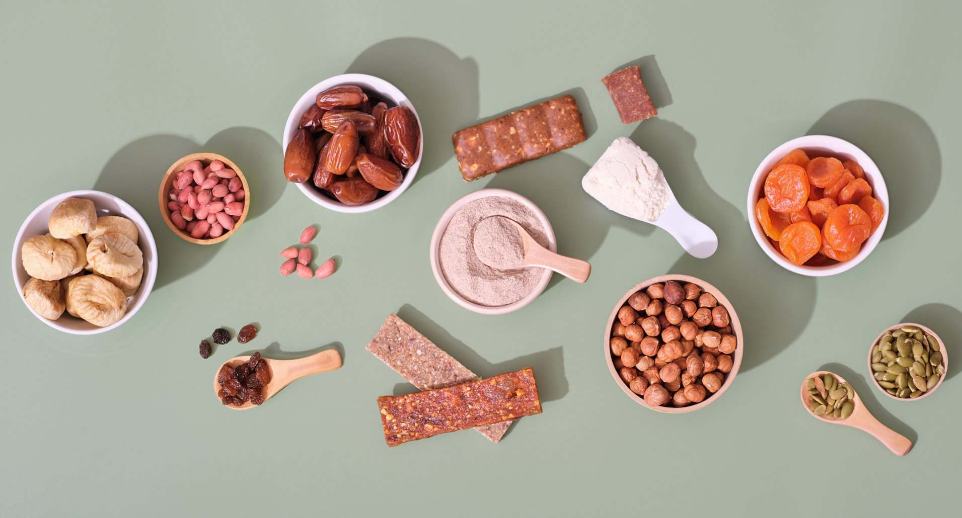 NutriFusion image of assorted nuts, dried fruits, seeds, and protein bars arranged as whole-food snacks.