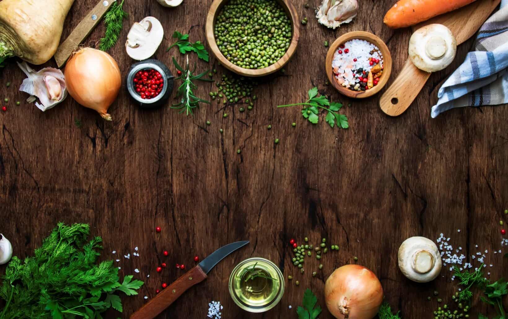 NutriFusion’s fresh ingredients, like onions, garlic, mushrooms, herbs, and spices arranged on a wooden surface.