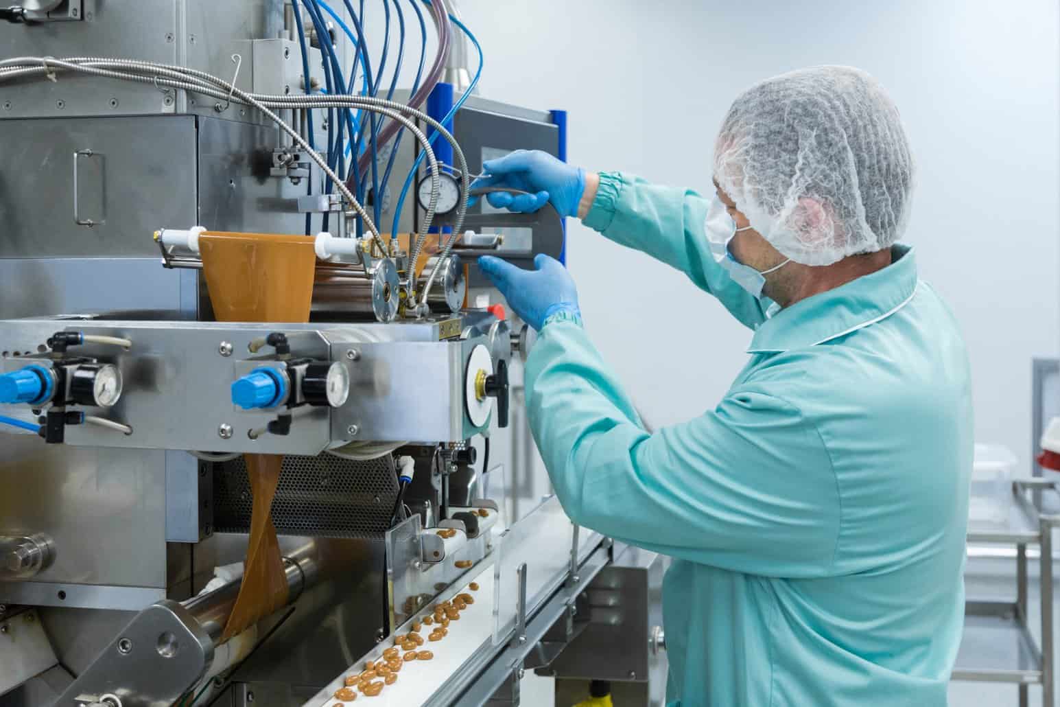 Food factory worker operating industrial processing equipment at NutriFusion Faculty.