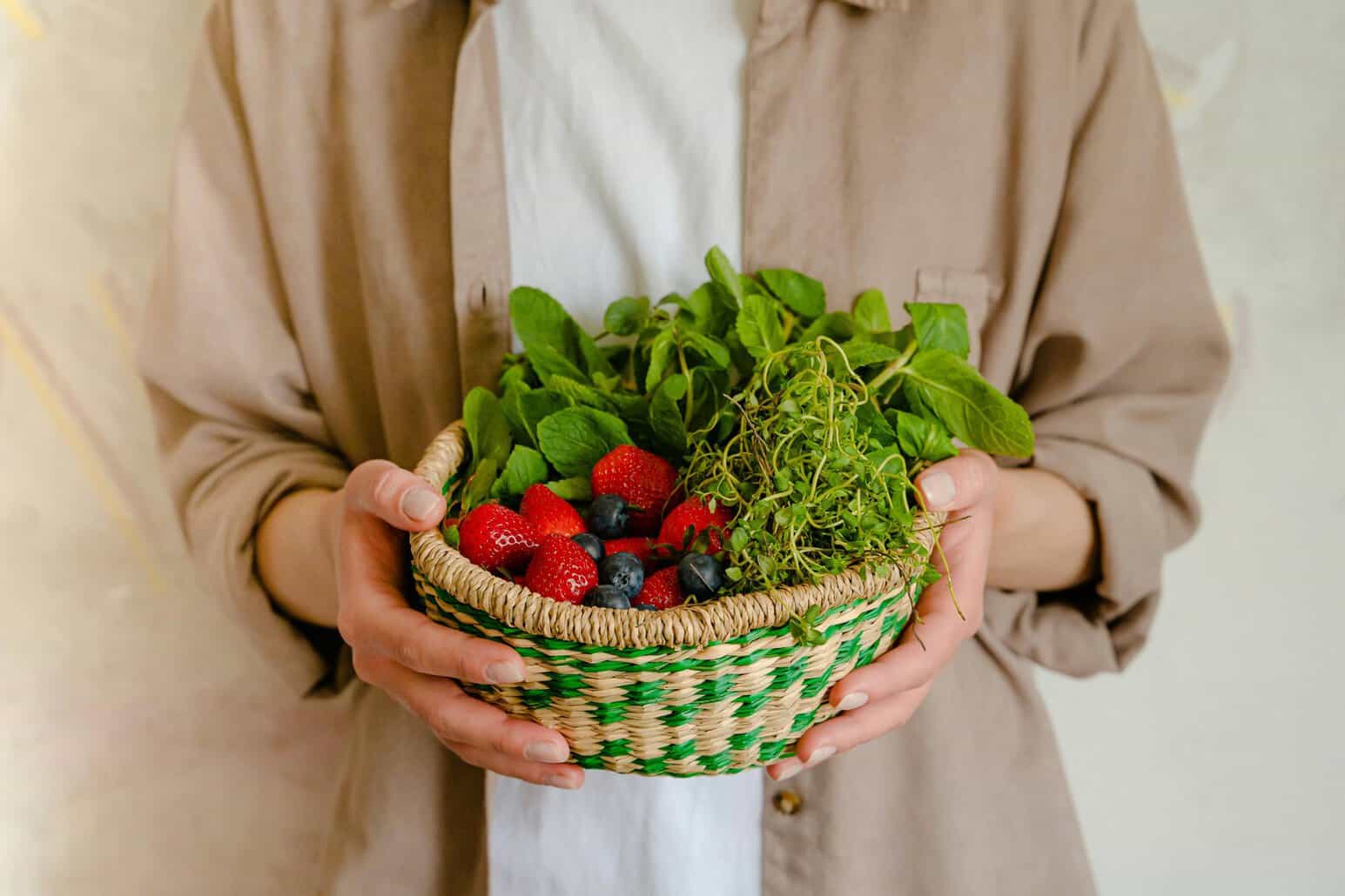 This photo features a person holding the best superfoods in a basket